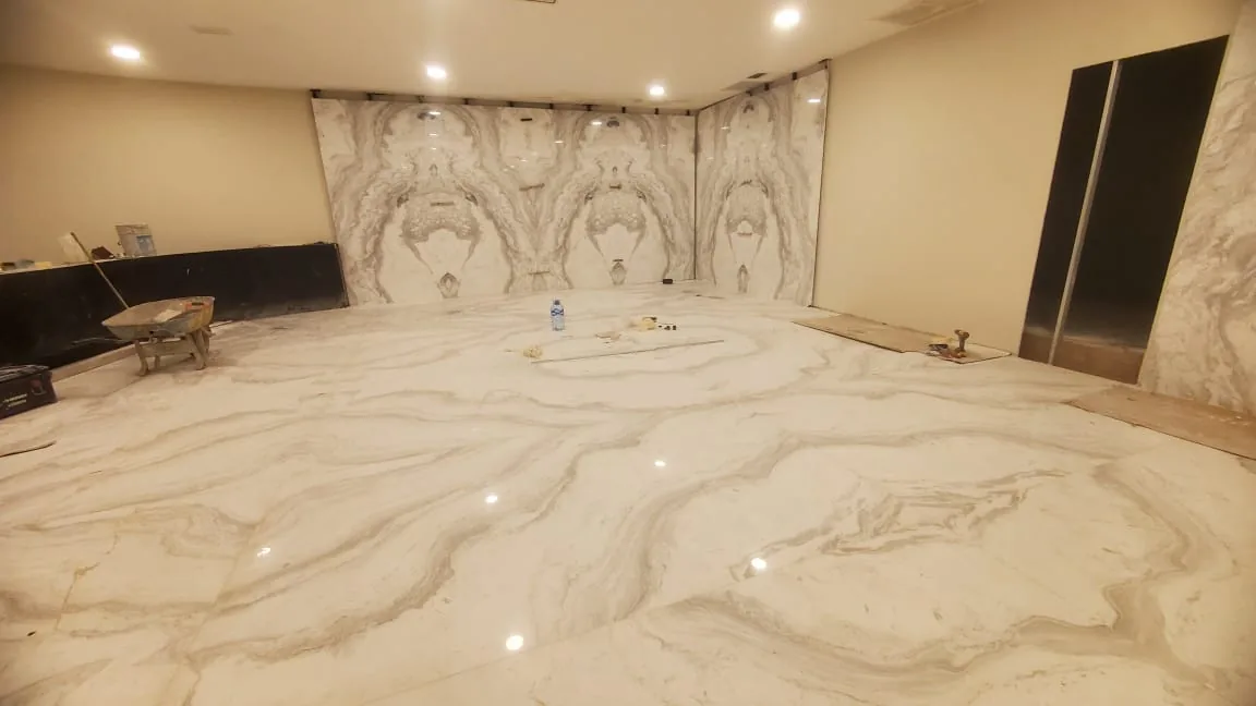 Piso y muro revestidos con placas de gran formato y veta continua